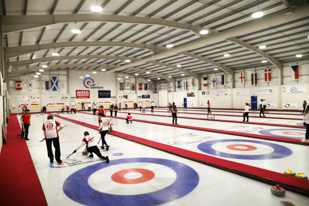 Overzicht van de curlinghal in Aberdeen waar meerdere curlingwedstrijden tegelijk gespeeld worden op een eerdere editie van het WK mixed curling.
